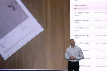 USDA presentation on stage at Palantir's AIPCon 10, with farm acreage-reporting software on the screen